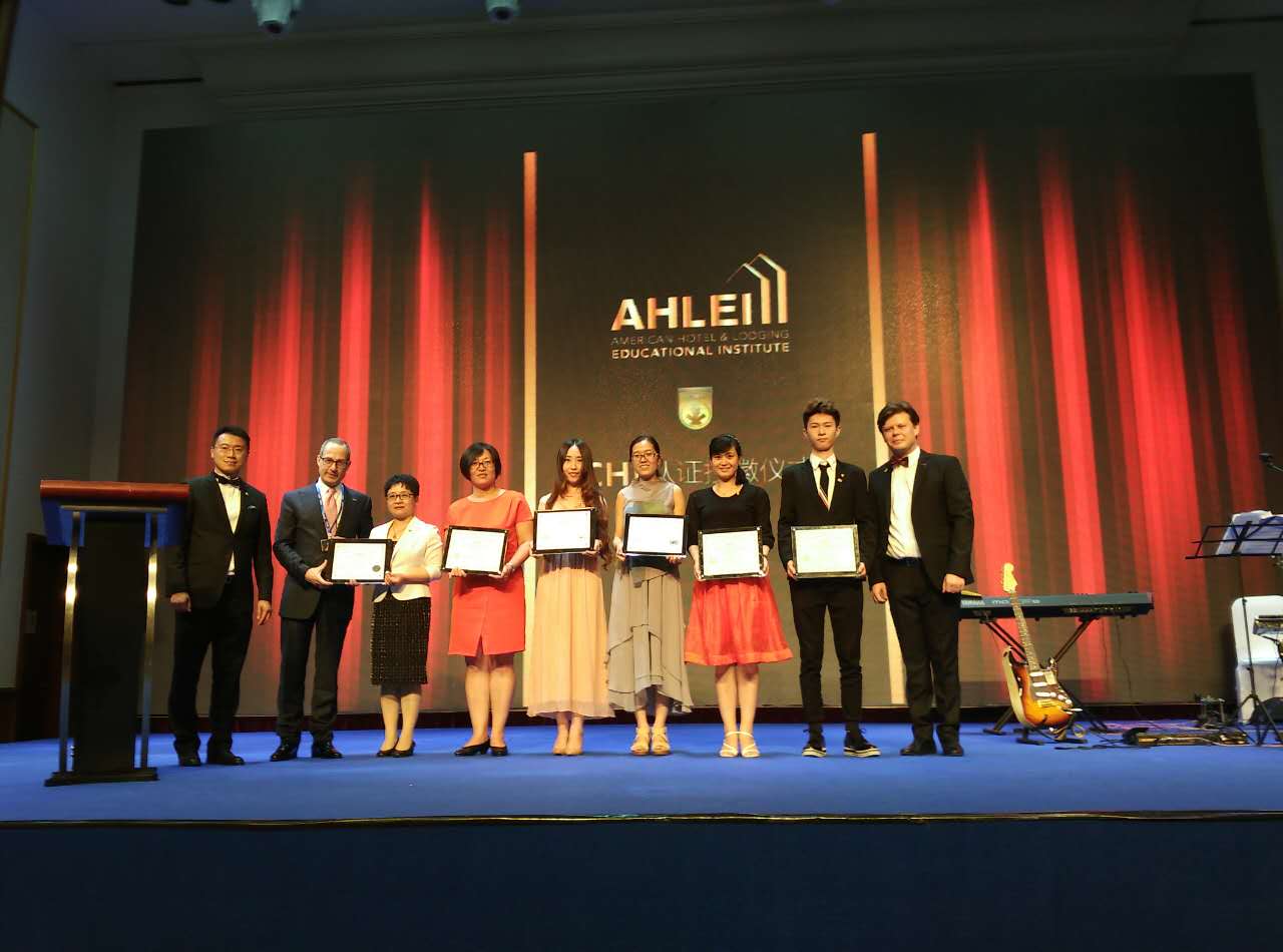 商务旅游系徐硕、杨梦璐两位教师代表上台参加CHI（注册酒店培训讲师）授徽仪式